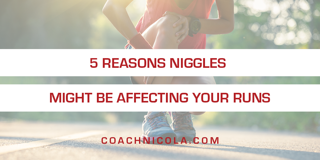 5 reasons niggles might be affecting your runs. Photo of a woman dressed for a run, crouching down with her hand on her knee and shin